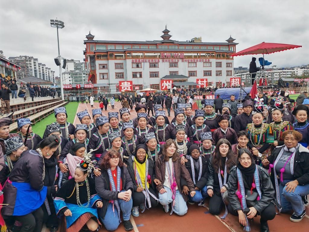 法國(guó)青年在“村超”賽場(chǎng)邊與參加表演的村民合影。新華社記者 羅羽 攝