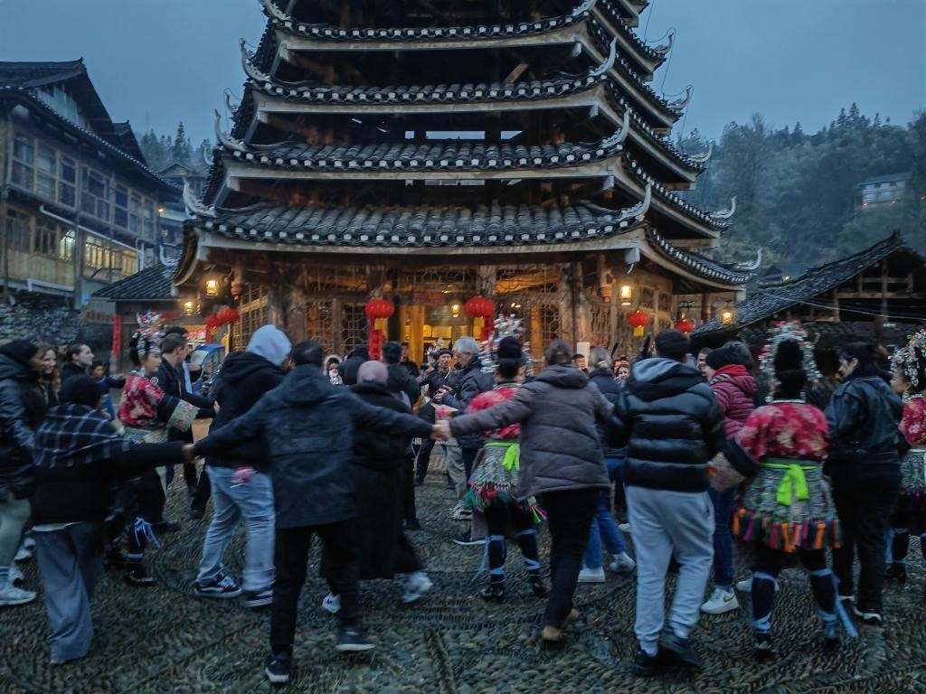 法國(guó)青年與當(dāng)?shù)卮迕駹渴痔?。新華社記者 羅羽 攝