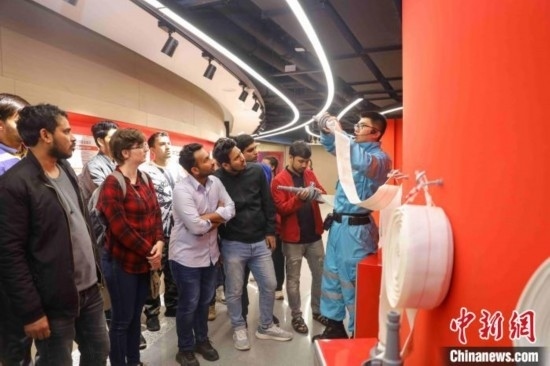 5月9日，工作人員指導(dǎo)留學(xué)生正確使用消防水帶。張鷹 攝