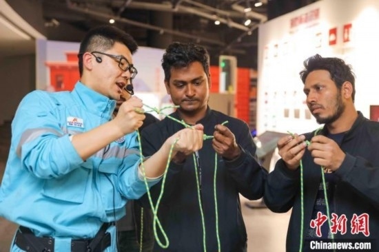 5月9日，工作人員指導(dǎo)留學(xué)生學(xué)習(xí)打繩結(jié)。張鷹 攝