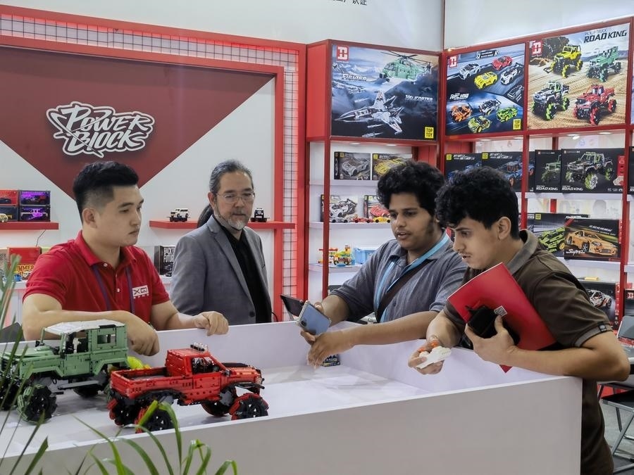 在第135屆廣交會第三期現場，采購商在廣東信宇科技股份有限公司展位選購、體驗積木遙控車產品（5月2日攝）。新華社記者 洪澤華 攝