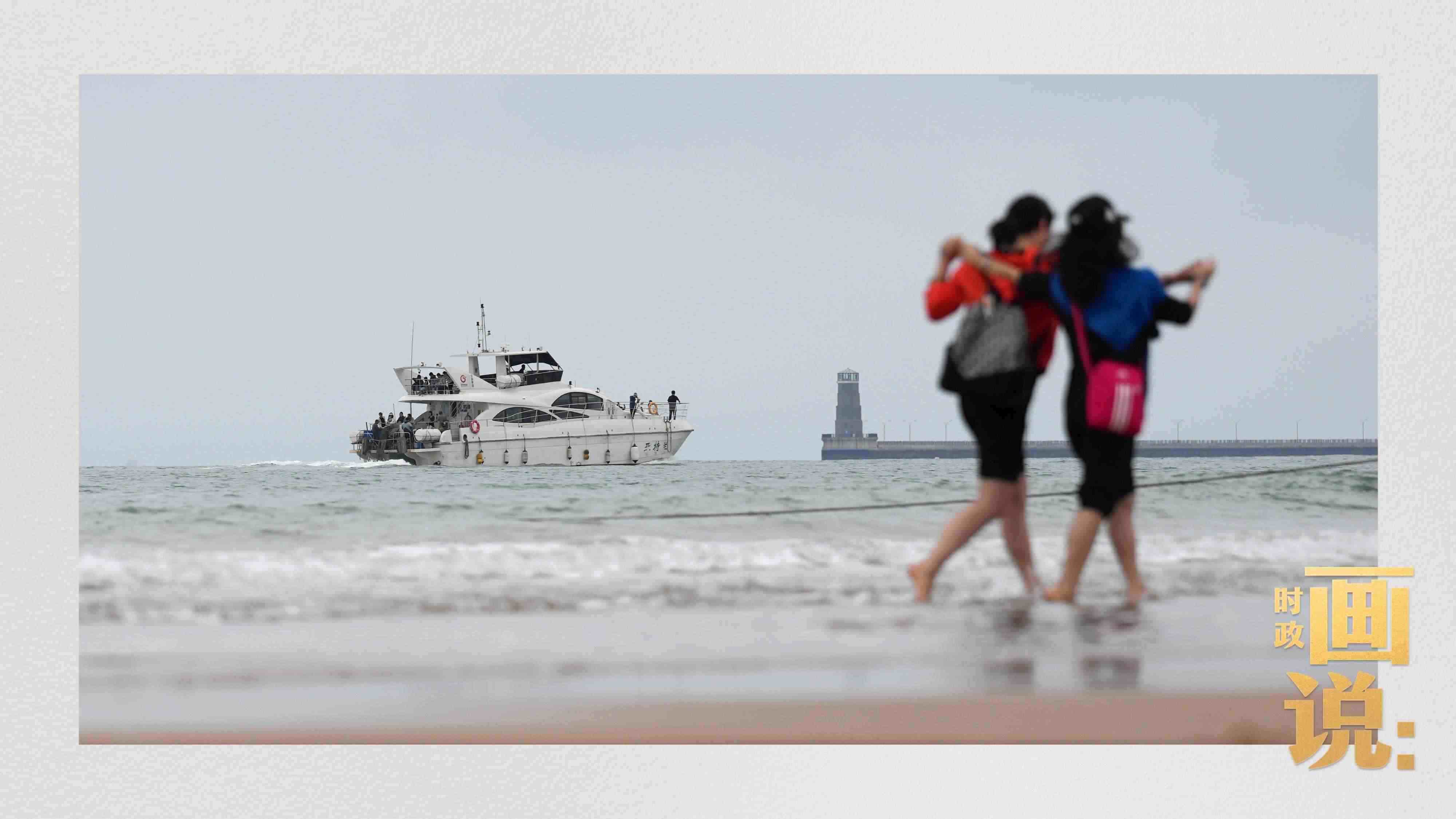 △日照陽光海岸綠道上的萬平口景區(qū)，一對(duì)游客在海浪中翩然起舞。