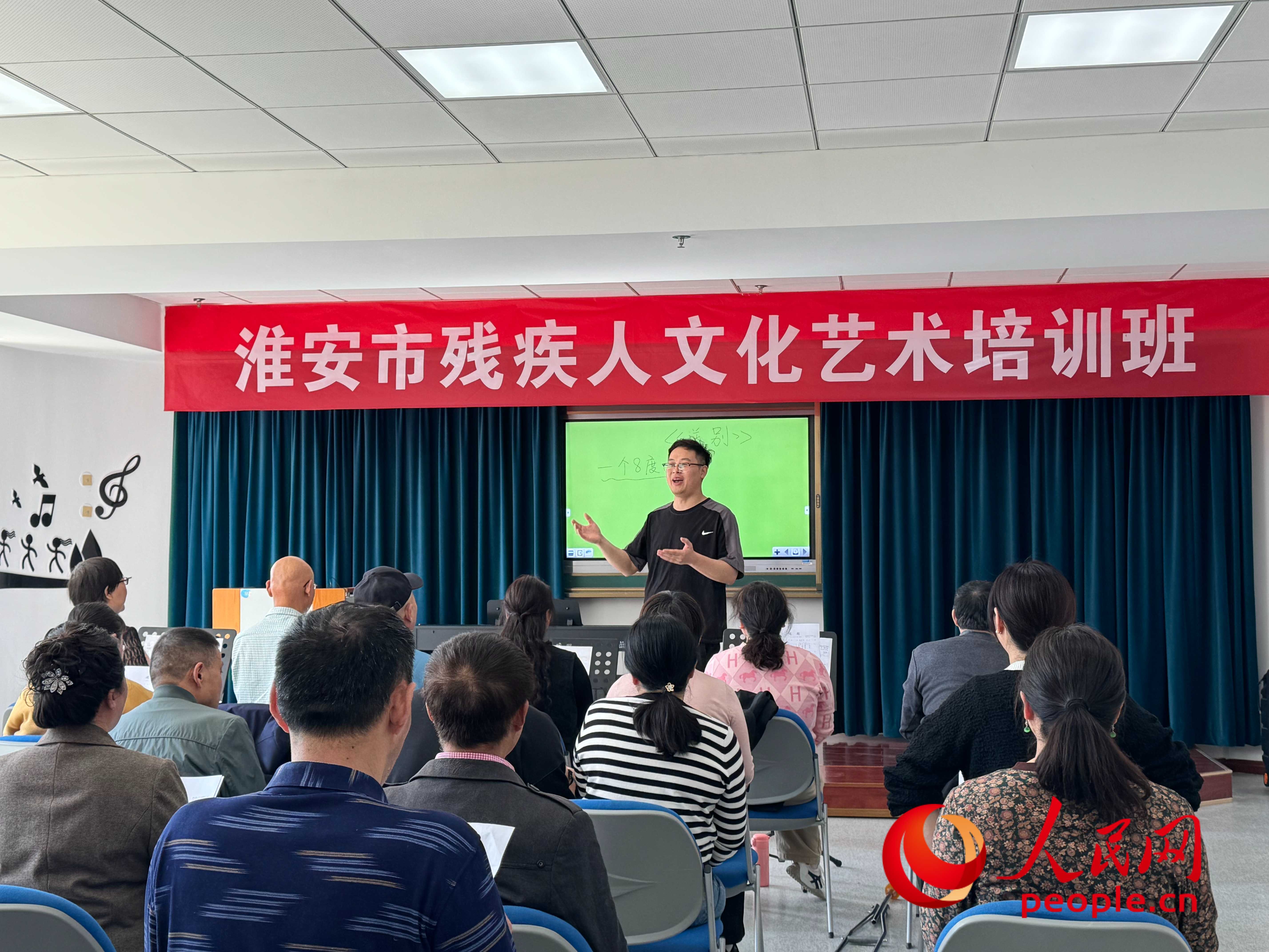 在淮安市殘疾人文化藝術培訓班上，聲樂老師在教殘疾人唱《送別》這首歌曲。人民網 周靜圓攝