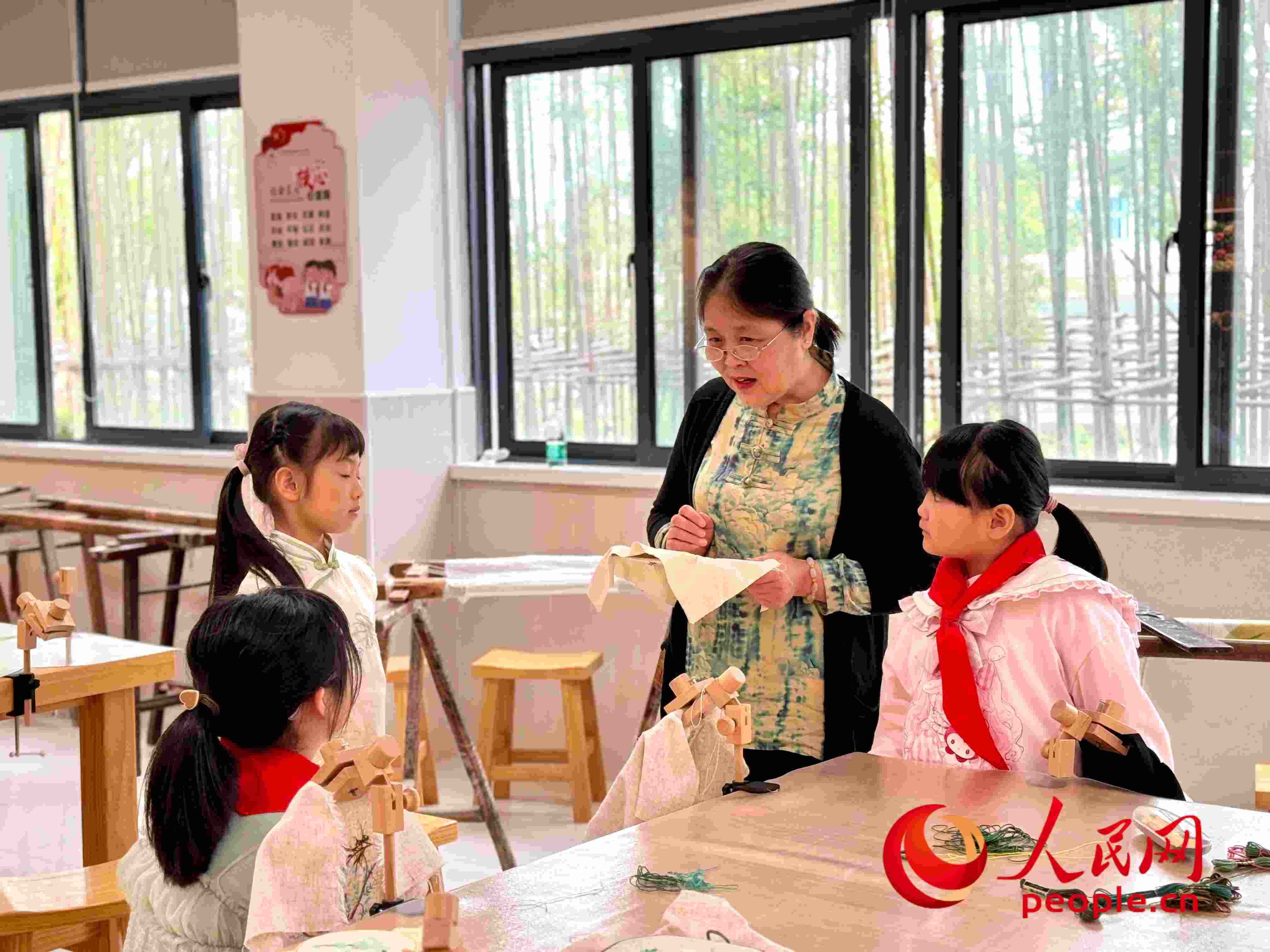顧建珍（左三）在教孩子們刺繡知識。人民網 周靜圓攝