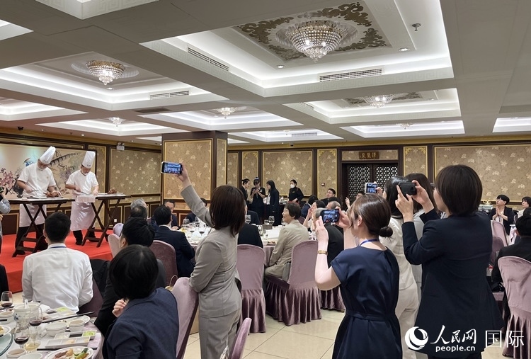 國家級非物質(zhì)文化遺產(chǎn)、全聚德片鴨工藝吸引代表團(tuán)成員拍照留念。