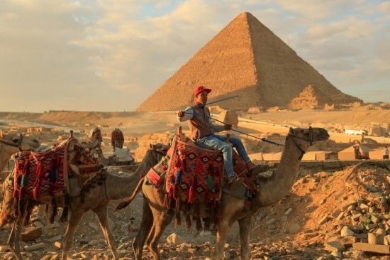 1月24日，商販騎駱駝離開埃及吉薩金字塔景區(qū)。新華社記者 隋先凱 攝