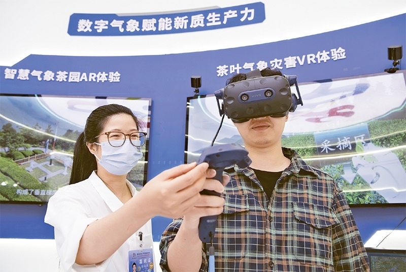 2024年5月23日，第七屆數(shù)字中國(guó)建設(shè)峰會(huì)現(xiàn)場(chǎng)體驗(yàn)區(qū)在福州海峽國(guó)際會(huì)展中心向?qū)I(yè)觀眾開(kāi)放。本次現(xiàn)場(chǎng)體驗(yàn)區(qū)圍繞本屆峰會(huì)主題“釋放數(shù)據(jù)要素價(jià)值，發(fā)展新質(zhì)生產(chǎn)力”，設(shè)置“數(shù)字惠民”、“數(shù)字能力”、“數(shù)字基礎(chǔ)”、“數(shù)字生態(tài)”、“數(shù)字賦能”五大板塊。圖為一名觀眾（右）在數(shù)字氣象賦能新質(zhì)生產(chǎn)力展臺(tái)上進(jìn)行體驗(yàn)。 新華社記者 魏培全/攝
