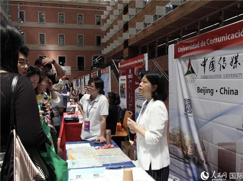 旅西華人華僑在展臺前咨詢。人民網(wǎng)記者 許海林?jǐn)z