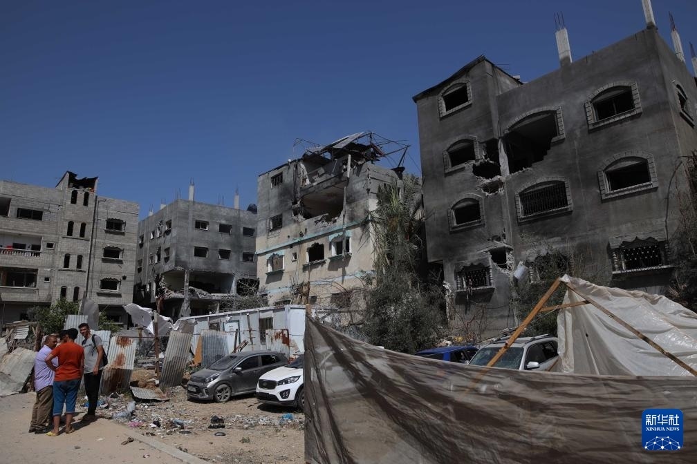 這是6月8日在加沙地帶中部努賽賴特難民營拍攝的在以軍襲擊中受損嚴(yán)重的房屋及車輛。新華社發(fā)（馬爾萬·達烏德攝）
