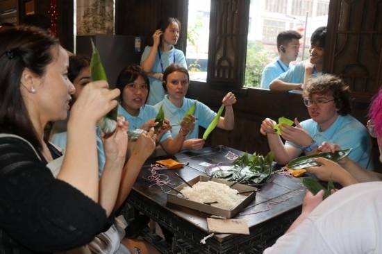 6月9日，美國青年代表在重慶永川松溉古鎮(zhèn)體驗包粽子。新華社記者 周思宇 攝