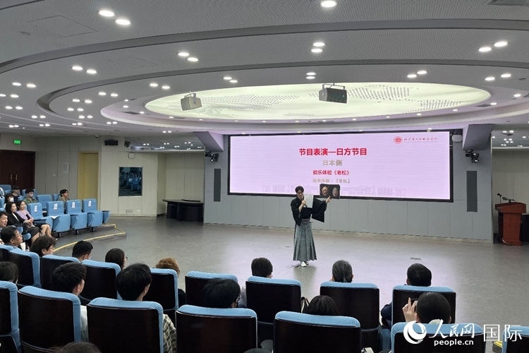 日本大學(xué)生介紹能樂知識。人民網(wǎng)記者 陳思攝