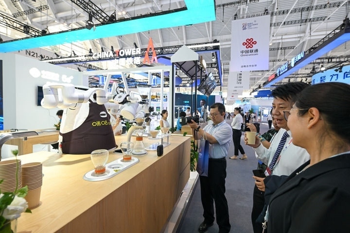 6月20日，與會(huì)者品嘗機(jī)器人沖調(diào)出的咖啡。新華社記者 孫凡越 攝