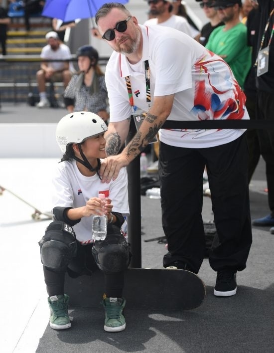 6月20日，鄭好好（左）在比賽間隙與教練互動，她在預(yù)賽中最佳成績?yōu)?2.60分。當(dāng)日，巴黎奧運會資格系列賽布達佩斯站滑板女子碗池預(yù)賽在布達佩斯舉行。新華社記者 賀燦鈴 攝