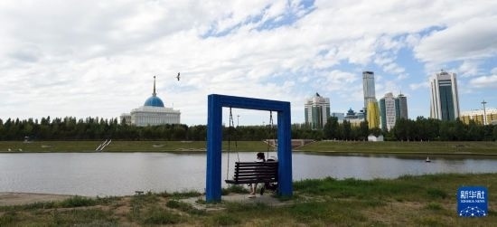 6月30日，一名女子在哈薩克斯坦首都阿斯塔納伊希姆河畔休息。新華社記者 王建華 攝