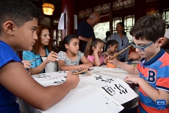 7月4日，在馬耳他桑塔露琪亞市的中國古典園林“靜園”，人們體驗中國書法。新華社發(fā)（喬納森·博格 攝）