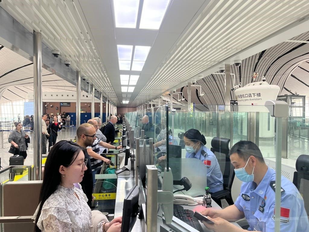 7月5日，北京大興國(guó)際機(jī)場(chǎng)邊檢站民警正在辦理邊檢查驗(yàn)手續(xù)。（北京大興國(guó)際機(jī)場(chǎng)邊檢站供圖）