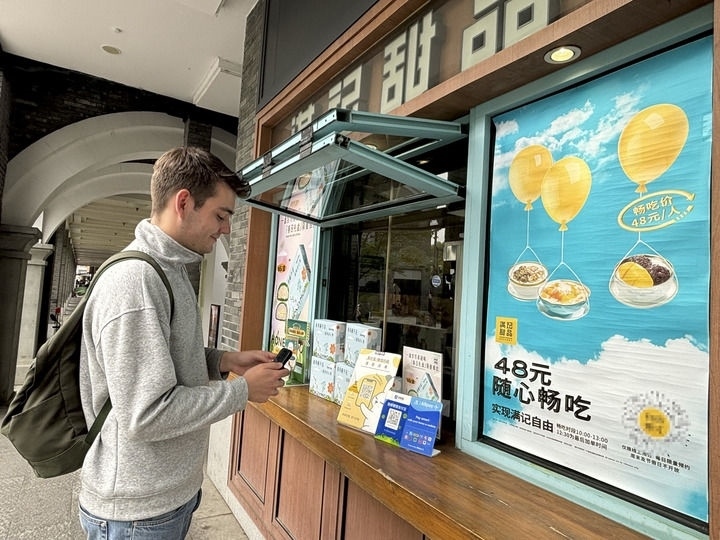 來(lái)自德國(guó)的留學(xué)生理查德在杭州西湖邊一家商鋪使用支付寶掃碼支付（2024年4月11日攝）。新華社發(fā)