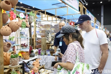 游客在蘭納博覽會(huì)特色展位上選購(gòu)工藝品。人民網(wǎng)記者楊一攝