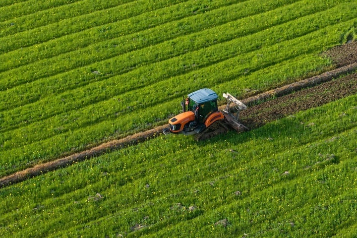 2024年3月19日，在湖南省常德市鼎城區(qū)謝家鋪鎮(zhèn)港中坪村，村民駕駛農(nóng)機翻耕田地（無人機照片）。新華社記者 陳思汗 攝