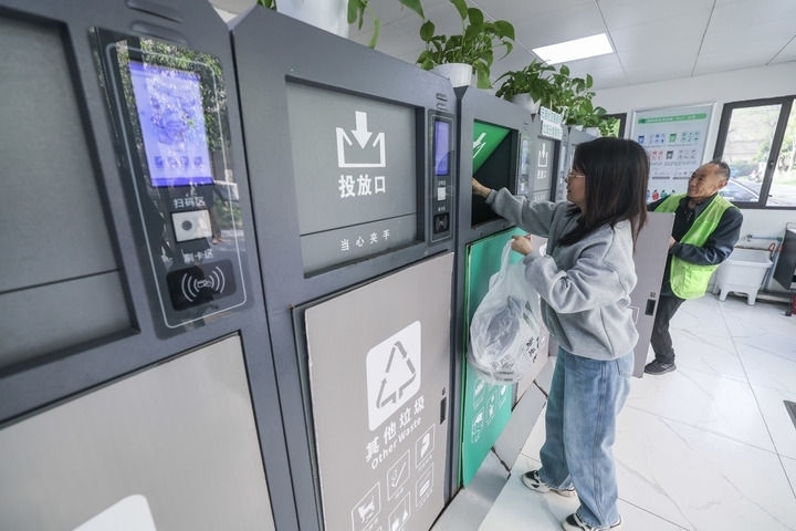 2024年4月10日，在浙江省湖州市吳興區(qū)飛英街道新華府小區(qū)內(nèi)，居民在垃圾分類智能系統(tǒng)的指導(dǎo)下進行垃圾分類投放，居民的投放情況將實時匯總到智慧服務(wù)平臺，會有相應(yīng)的積分獎勵。新華社記者 徐昱 攝