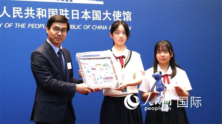 日本小大使向中國(guó)駐日本大使館臨時(shí)代辦施泳贈(zèng)送當(dāng)?shù)靥厣Y品。人民網(wǎng) 許可攝