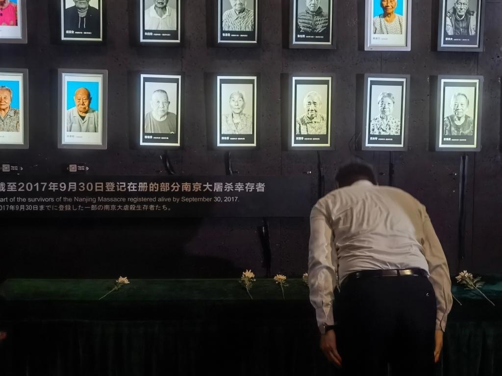 7月18日，人們向離世的南京大屠殺幸存者獻(xiàn)花、鞠躬。新華社記者邱冰清 攝