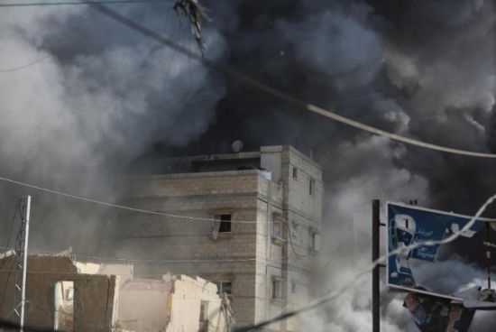 7月21日，在加沙地帶中部的努賽賴特難民營，遭以軍空襲的建筑冒出滾滾濃煙。新華社發(fā)（馬爾萬·達(dá)烏德攝）