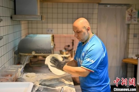 近日，韋榮耀在自家披薩小店內(nèi)忙活。俞靖 攝