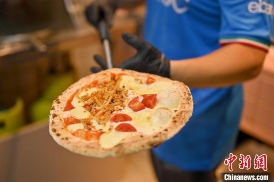近日，韋榮耀展示他制作的“老友味”披薩。 俞靖 攝