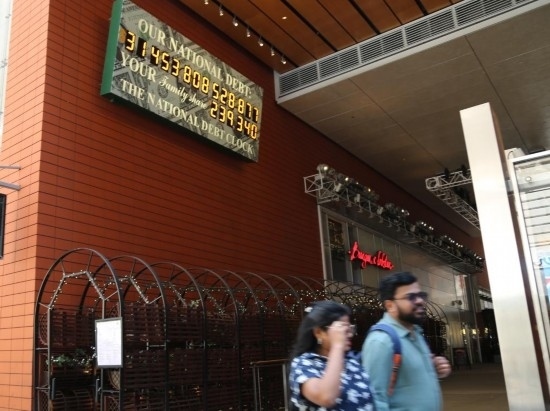 2023年5月29日，人們經(jīng)過美國紐約曼哈頓的“國債鐘”。“國債鐘”是一個大型計(jì)數(shù)器，它實(shí)時更新美國的公共債務(wù)總額，并顯示出每個美國家庭所要負(fù)擔(dān)的數(shù)額。 新華社記者劉亞南攝