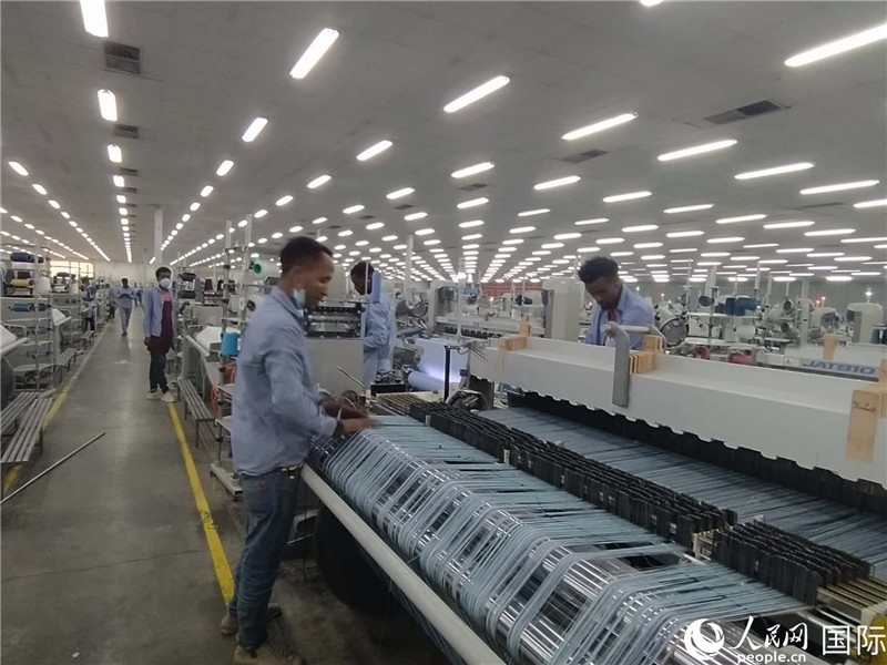 無(wú)錫金茂埃塞面料廠車(chē)間內(nèi)，當(dāng)?shù)毓と苏谝唤z不茍地作業(yè)。人民網(wǎng)記者 黃培昭攝