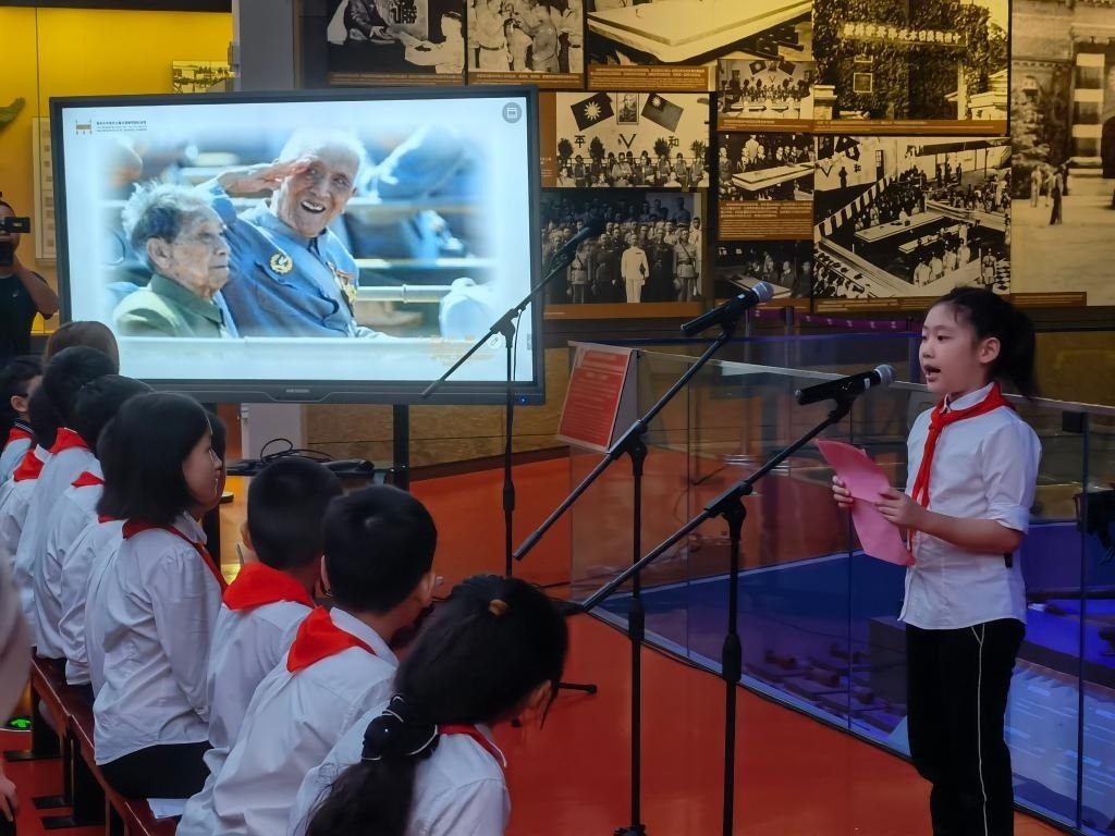 南京市科睿小學(xué)二年級學(xué)生章若初為大家講述抗戰(zhàn)老兵手印的故事。 新華社記者 邱冰清 攝