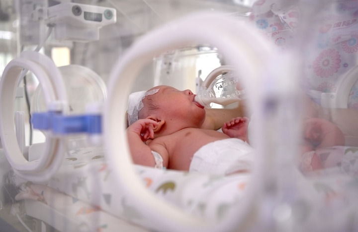 2024年6月1日，在西安國際醫(yī)學(xué)中心醫(yī)院新生兒科病房，護(hù)士為新生兒喂奶。 新華社記者 劉瀟 攝