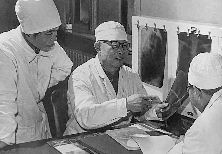1980年1月16日，中日友好醫(yī)院首任院長(zhǎng)辛育齡（中）在內(nèi)蒙古結(jié)核病院與胸外科醫(yī)師討論病例（翻拍照片）。 新華社發(fā)
