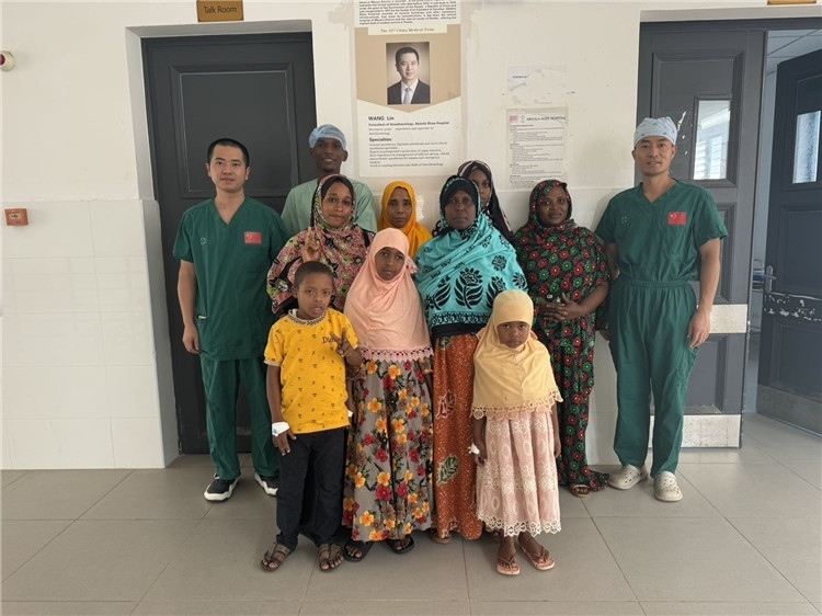 李廣（右一）和王林醫(yī)生與部分患者合影。中國援桑醫(yī)療隊(duì)供圖