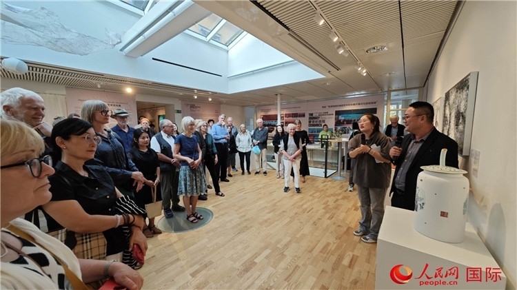 參展人、景德鎮(zhèn)陶瓷大學(xué)美術(shù)學(xué)院副院長邵長宗（右一）向來賓介紹參展作品。人民網(wǎng)記者 殷淼攝