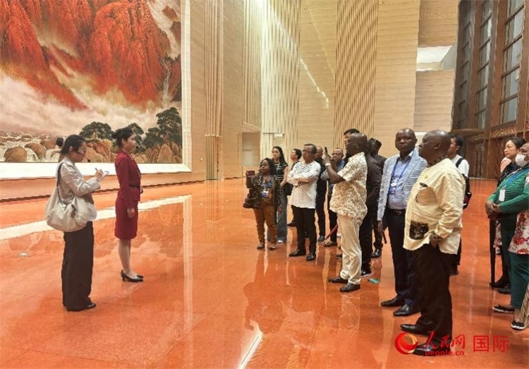 代表團在入口處聽取講解。人民網(wǎng) 曹欣悅攝