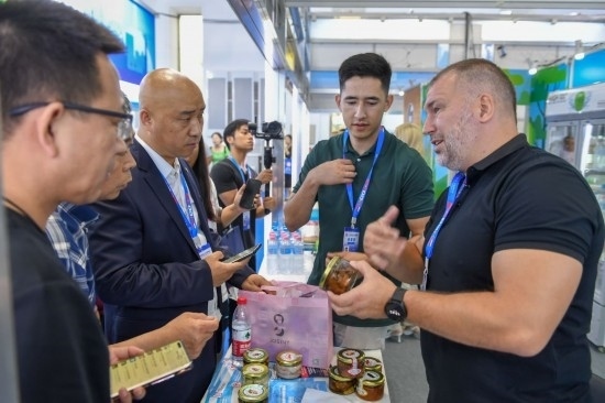 2023年8月23日，在第十四屆中國(guó)—東北亞博覽會(huì)東北亞商品館，俄羅斯參展商向參觀者介紹商品。