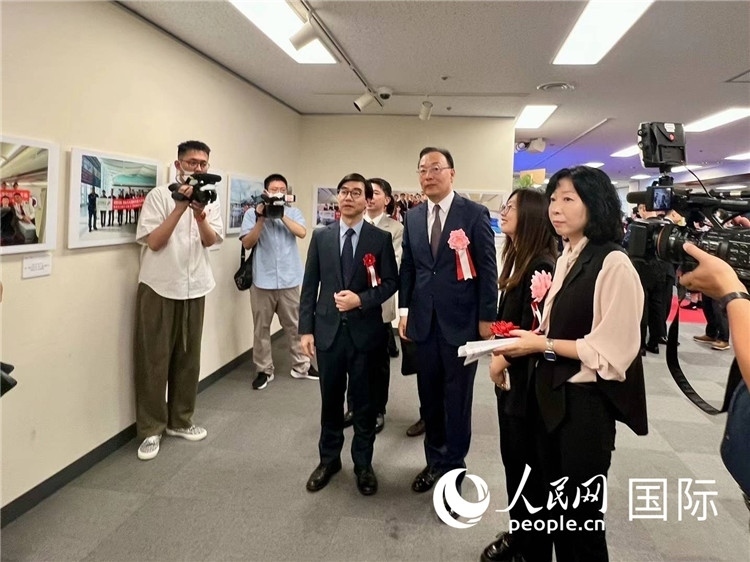 中國(guó)國(guó)際航空日韓地區(qū)支社支社長(zhǎng)馮力為中國(guó)駐日本大使館臨時(shí)代辦施泳等嘉賓介紹展出圖片。人民網(wǎng) 許可攝
