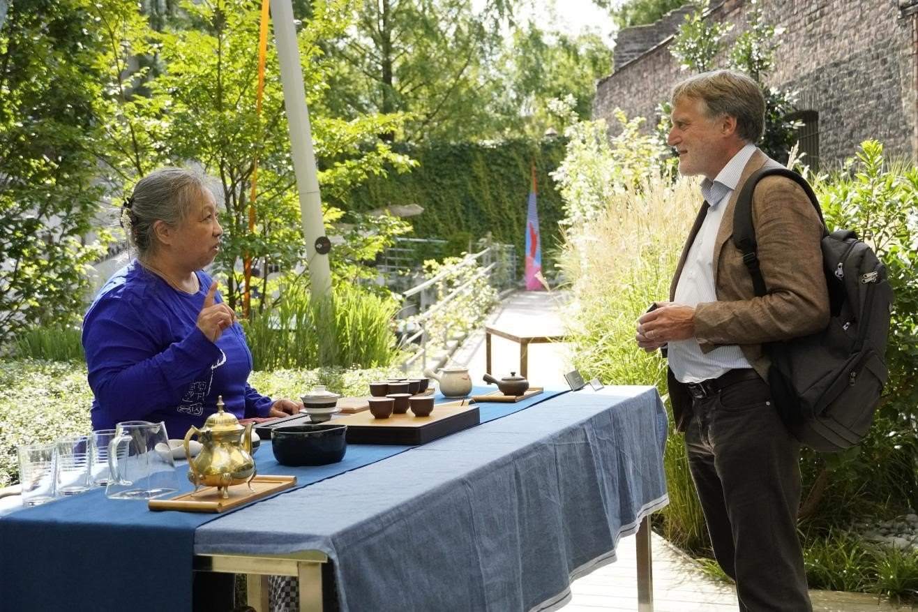 在博物館的戶外花園來賓品味中國茶藝。比利時維他命文化傳媒供圖