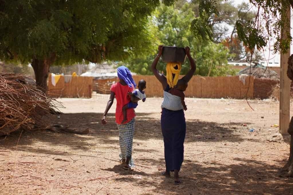 2023年3月20日，在塞內(nèi)加爾久爾貝勒區(qū)的泰內(nèi)富勒村，村民將取到的水運回家。新華社記者 王子正 攝