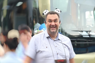 參訪熊貓谷前，塞爾維亞“一帶一路”研究所所長博揚·拉利奇戴上熊貓頭飾。（李佩藺 攝）