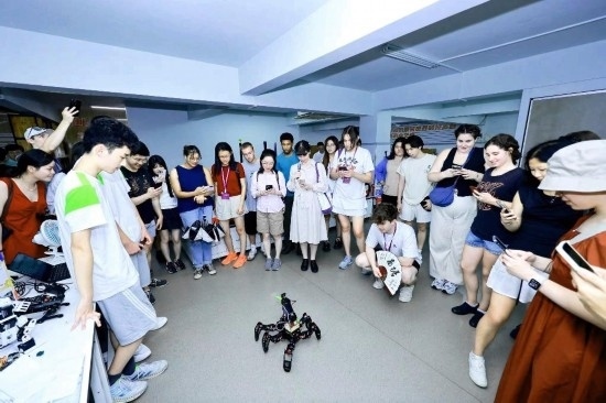 8月25日，中外青年在浙江杭州觀看機器人表演。新華社發(fā)（清華大學(xué)供圖）