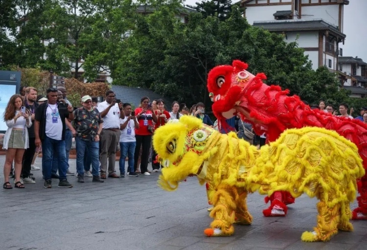 2024“一帶一路”媒體合作論壇聯(lián)合采訪調(diào)研行成員在樂山蘇稽古鎮(zhèn)觀看非遺舞獅表演。本報(bào)記者 伊霄攝