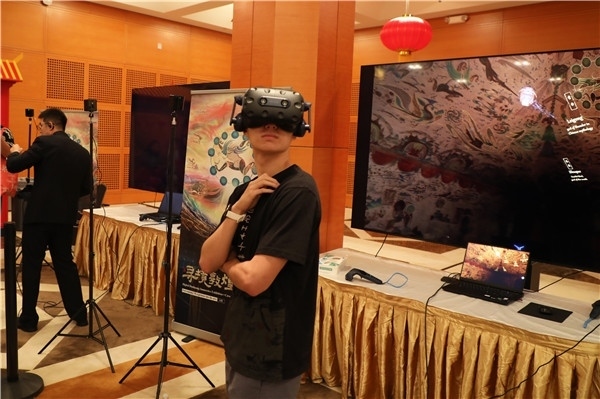1、在本次活動的展覽現(xiàn)場，敦煌研究院與騰訊展示了“數(shù)字藏經(jīng)洞”和“尋境敦煌”等創(chuàng)新互動產(chǎn)品。圖為當?shù)孛癖娡ㄟ^VR虛擬游覽洞窟。 人民網(wǎng)記者 李志偉攝