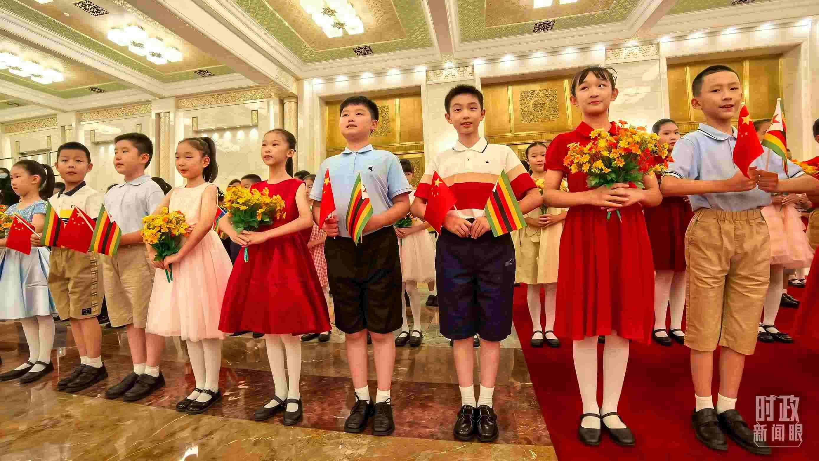 △現(xiàn)場歡迎津巴布韋總統(tǒng)訪華的青少年。（總臺央視記者鐘銳拍攝）