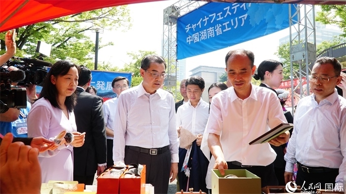 湖南展位工作人員向中國(guó)駐日本大使吳江浩介紹特色文創(chuàng)產(chǎn)品。人民網(wǎng) 蔣曉辰攝