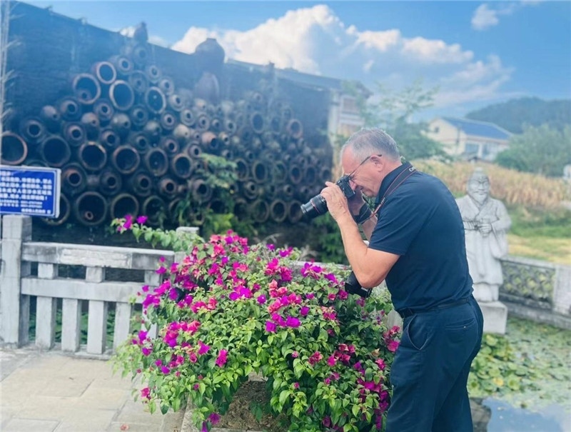 遠(yuǎn)處黔北民居錯(cuò)落有致，近處一只黑色的蝴蝶穿梭于粉紫色三角梅花叢間隙，與俄羅斯“大歐亞”總編輯弗拉基米爾·別列日內(nèi)赫的鏡頭玩起了捉迷藏，“你追我逃，不亦樂(lè)乎”。（張亞欣攝）