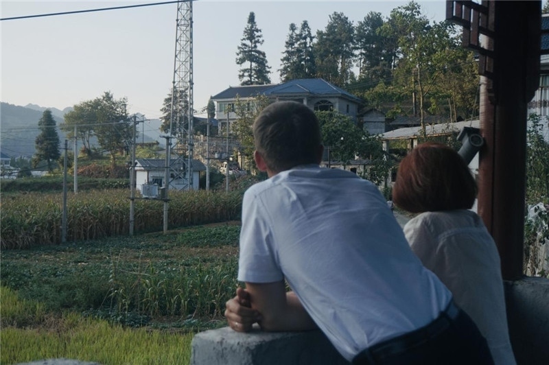 望得見(jiàn)山，看得見(jiàn)水，記得住鄉(xiāng)愁。每個(gè)人心中都有一個(gè)屬于自己的“花茂村”，在這方心田，走遍千山萬(wàn)水，鄉(xiāng)音未改鬢毛衰。吉爾吉斯斯坦《比什凱克晚報(bào)》第一副總編輯妮娜·尼奇博洛娃與《中國(guó)與俄羅斯》雜志社社長(zhǎng)奧列格·別列日內(nèi)赫攝在花茂村民居屋檐下并肩佇立，眺望山水，尋覓鄉(xiāng)愁。（李光裕攝）