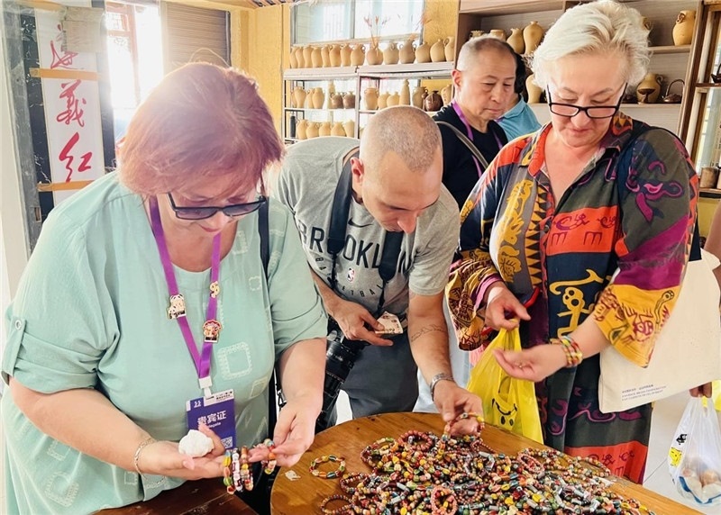 歐亞媒體考察團(tuán)成員在母氏陶藝館內(nèi)挑花了眼，色彩絢麗、質(zhì)地均勻的陶藝手串讓他們愛(ài)不釋手?！斑@里的東西都太實(shí)惠了！”塔吉克斯坦《索格特真理報(bào)》政論部主任娜塔利婭·多羅費(fèi)耶娃說(shuō)?；宓奶厣a(chǎn)品物美價(jià)廉，讓考察團(tuán)成員為家人好友買(mǎi)到了心儀的禮物，也為此次以四川成都為起點(diǎn)，路經(jīng)南充、廣安至貴州遵義的考察行程畫(huà)上了圓滿(mǎn)句號(hào)。（張亞欣攝）